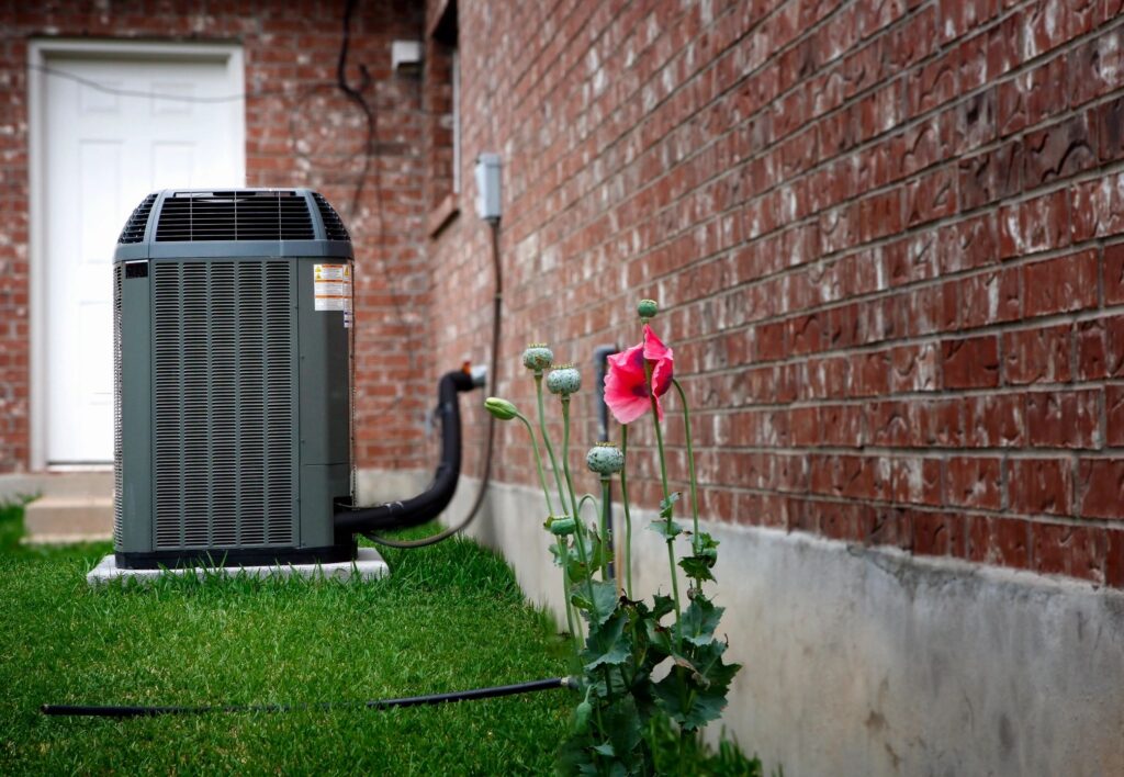 ac unit outside with lawn & flowers